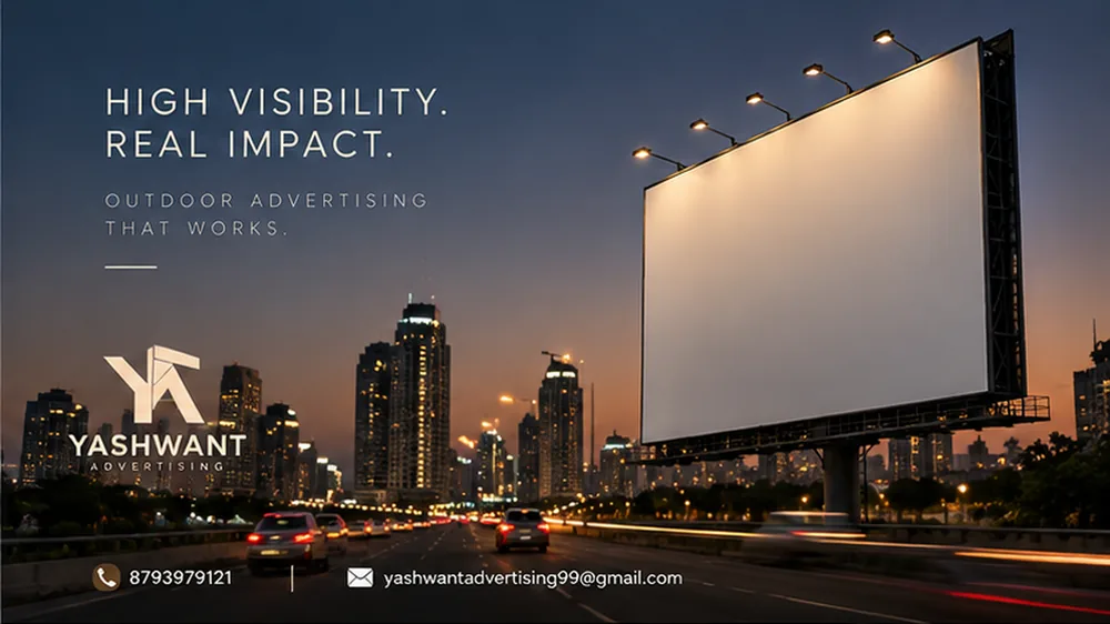 Yashwant Advertising billboard lit up beside a highway at night, with the city skyline in the background